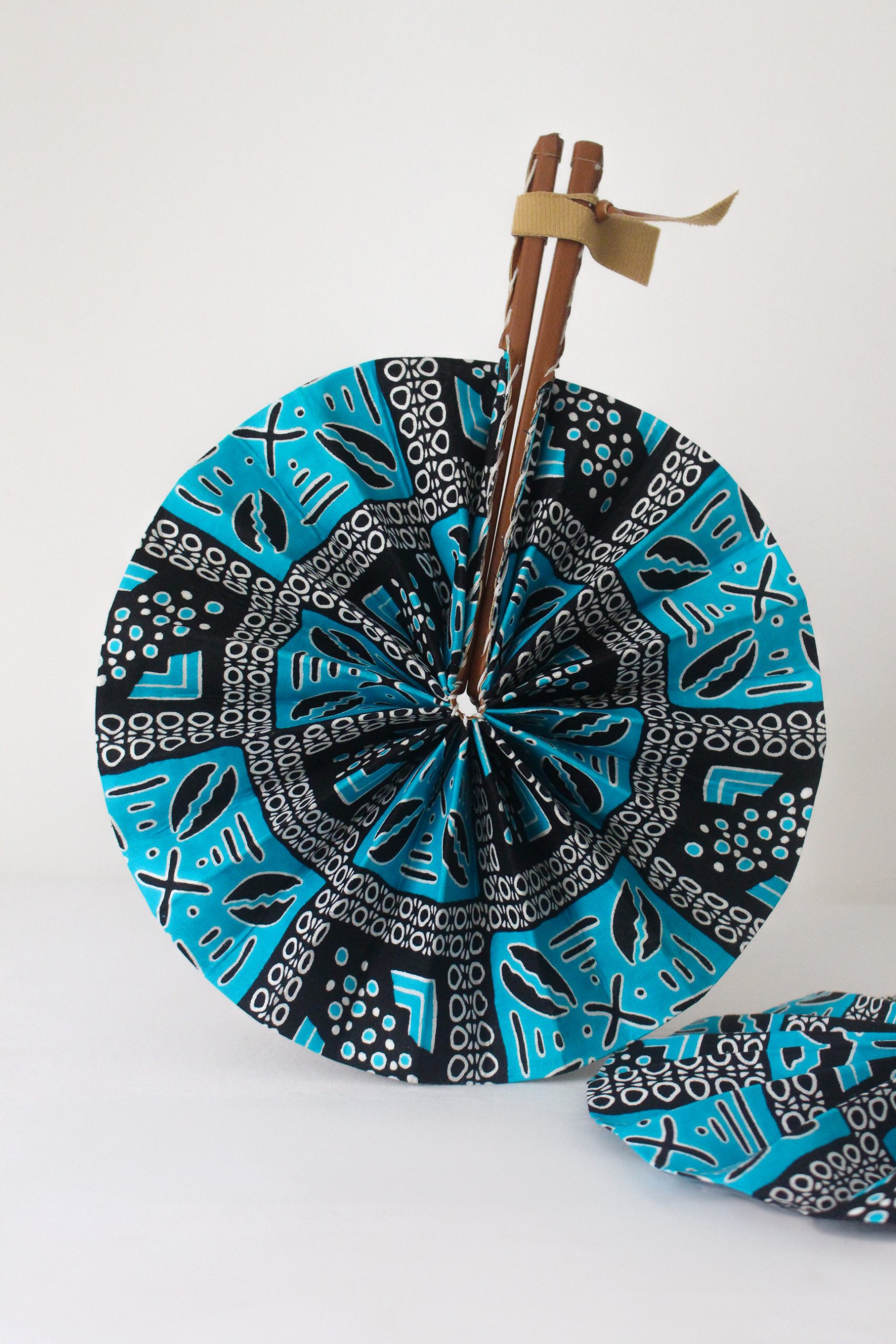 Éventail en wax bleu motifs cauris
