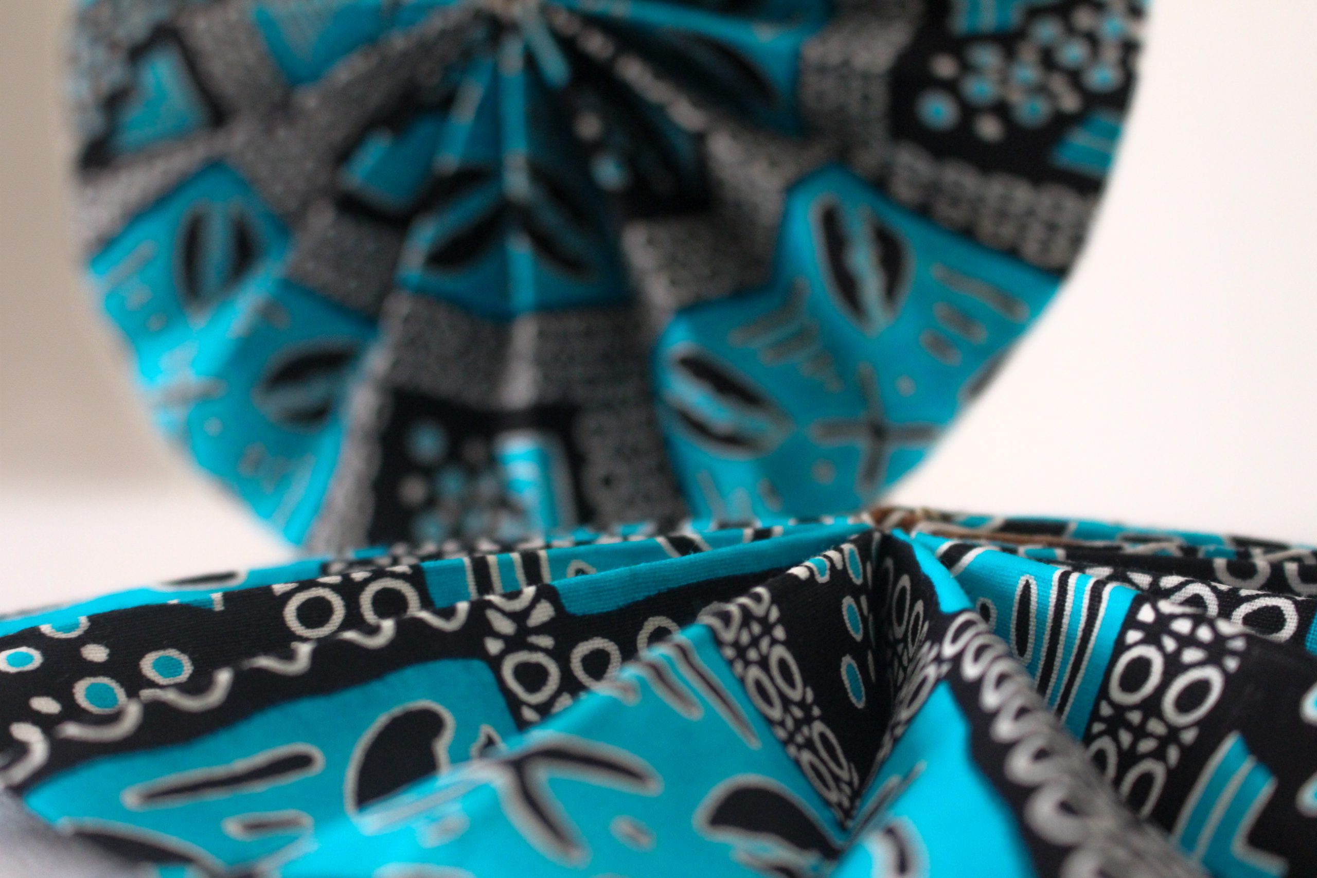Éventail en wax bleu motifs cauris